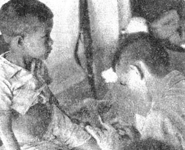 PFC Leon Monty examines child