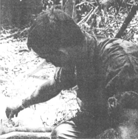 1Lt Richard Nash examines rice